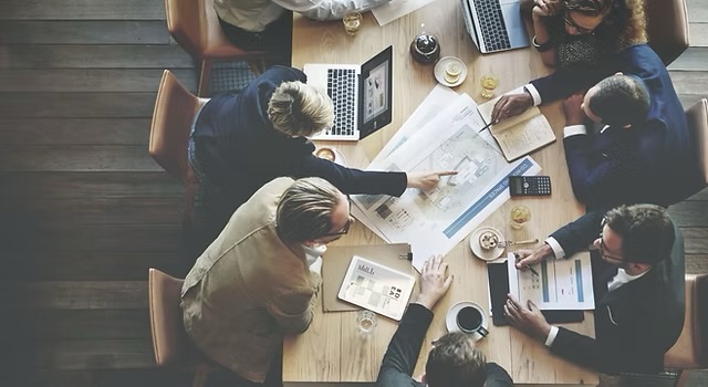 Professionals reviewing project plans together around a meeting table
